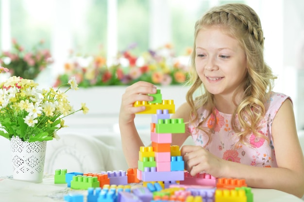 Bambina adorabile che gioca con blocchi di plastica colorati