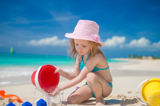 Bambina adorabile che gioca con i giocattoli sulla vacanza della spiaggia