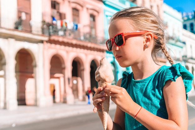 Bambina adorabile che mangia il gelato nella zona popolare a L'Avana Vecchia, Cuba.