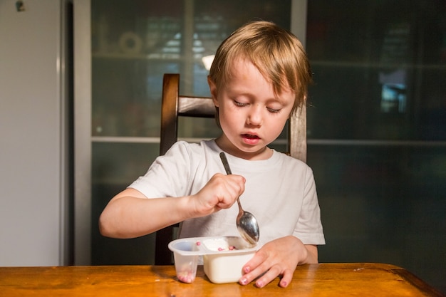 Bambina adorabile che mangia la ricotta con un cucchiaio