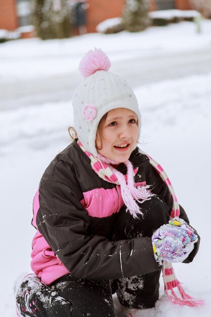 Bambina adorabile che si diverte in giornata invernale bambina che gioca per strada in inverno