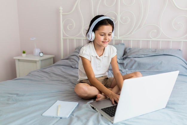 Bambina adorabile che utilizza il suo computer portatile