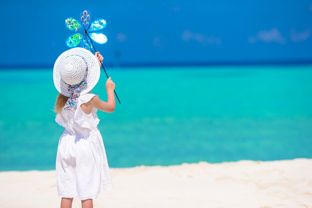 Bambina adorabile in cappello sulla spiaggia bianca