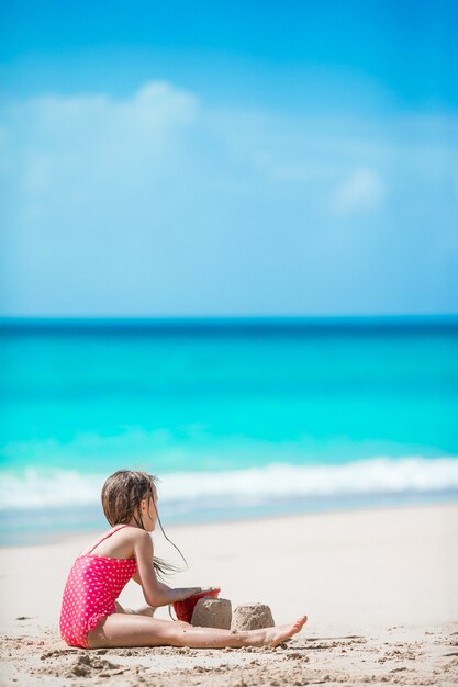 Bambina adorabile in costume da bagno alla spiaggia tropicale