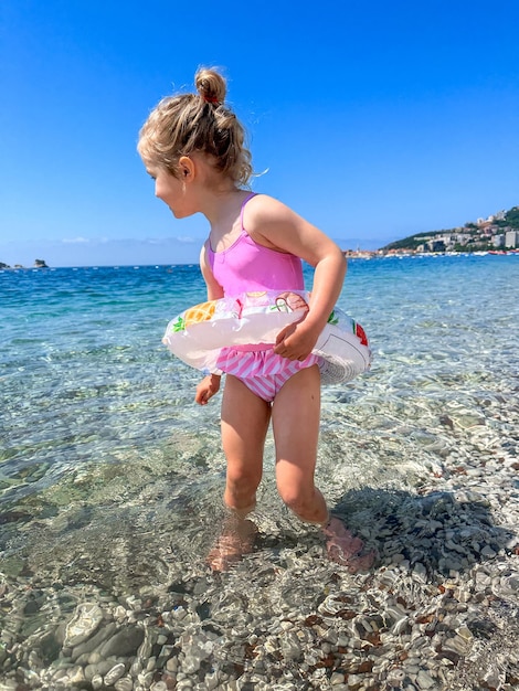 Bambina adorabile in spiaggia durante le vacanze estive