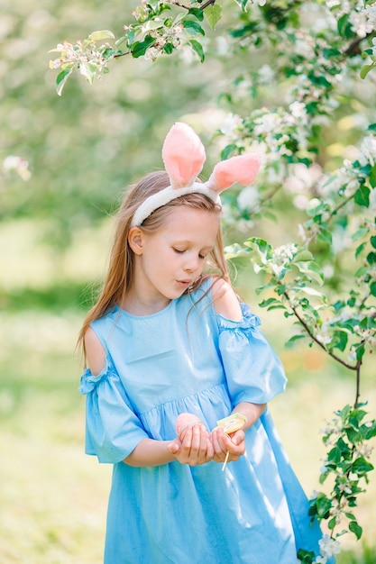 Bambina adorabile nel giardino fiorito della mela sulla bella giornata di primavera