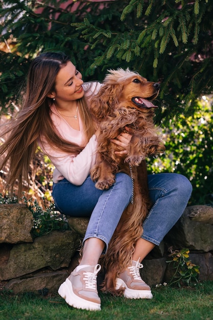 Bambina allegra che gioca con il suo cane nell'iarda della casa