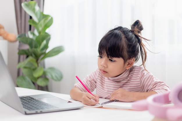 Bambina asiatica a casa che fa i compiti