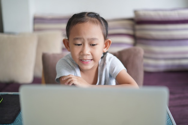 Bambina asiatica che studia la lezione online dei compiti, concetto di educazione online a distanza sociale a casa home