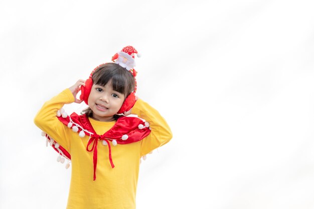 Bambina asiatica in cappello rosso della Santa su fondo bianco.