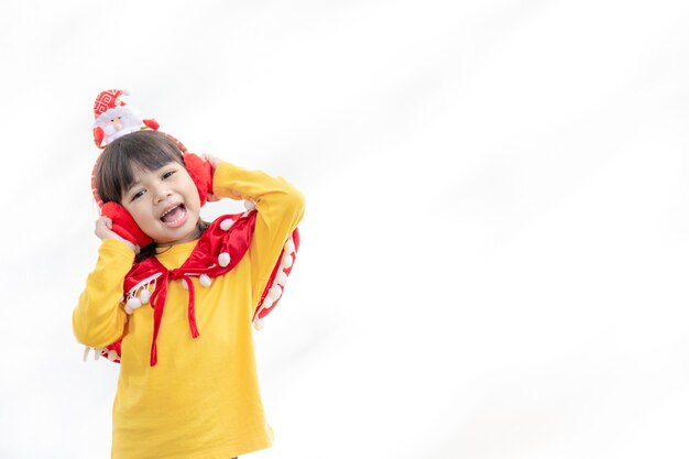 Bambina asiatica in cappello rosso della Santa su fondo bianco.