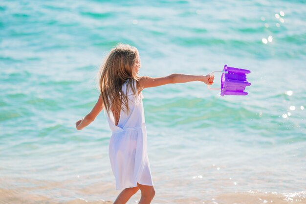 Bambina attiva sulla spiaggia divertendosi molto