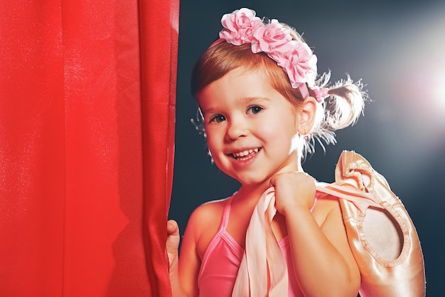 Bambina ballerina ballerina sul palco in scene laterali rosse