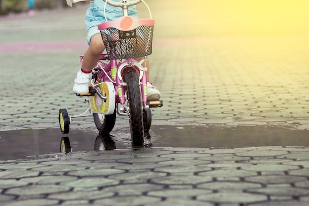 Bambina bambina a cavallo in bicicletta nel parco