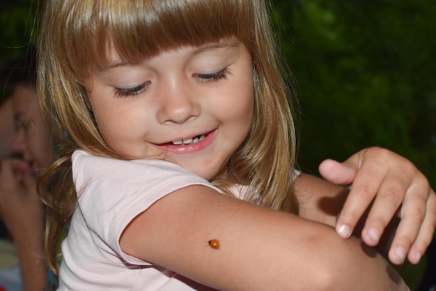 Bambina bambino che gioca con una coccinella all'aperto all'aperto