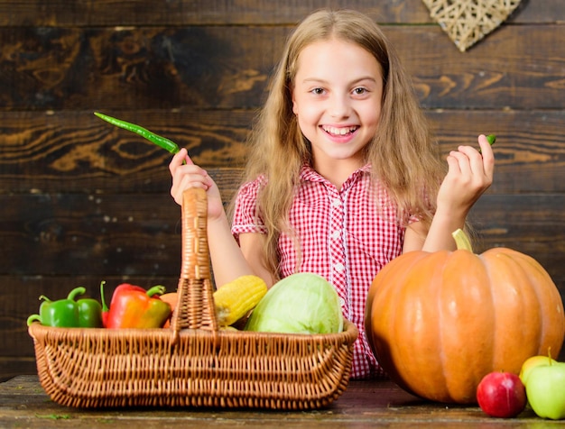 Bambina bambino godersi la vita in fattoria Giardinaggio biologico Kid agricoltore con sfondo di legno raccolto Coltiva il tuo cibo biologico Ragazza bambino al mercato agricolo con verdure biologiche Concetto di festa del raccolto