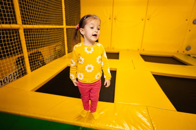 Bambina bambino sul trampolino al parco giochi giallo Bambino in spettacoli attivi