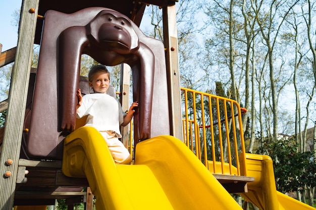 Bambina bionda attiva che gioca in un parco giochi