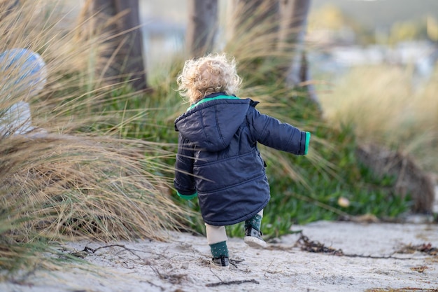 bambina bionda che esplora sulla sabbia sulla spiaggia in Australia