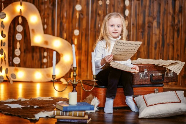 Bambina bionda che tiene i punteggi