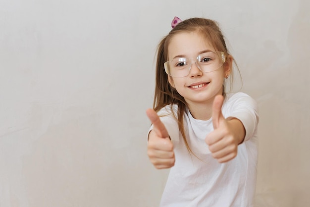 bambina bionda con rullo di pittura murale durante la ristrutturazione domestica