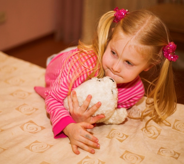 Bambina bionda con un peluche