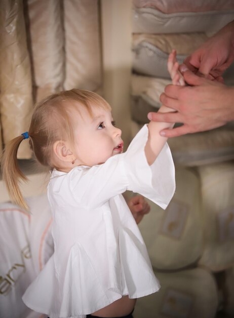 Bambina bionda felice nel negozio di tessuti Famiglia sullo shopping