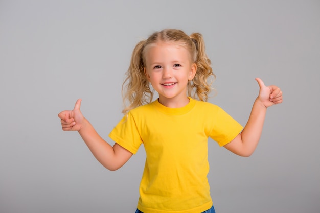 bambina bionda sorridente su sfondo chiaro