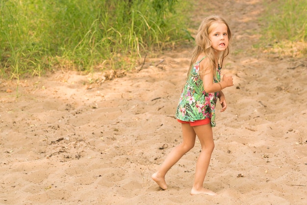 Bambina bionda su una spiaggia sabbiosa