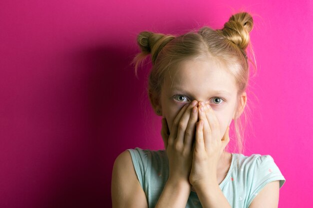 Bambina bionda su uno sfondo rosa