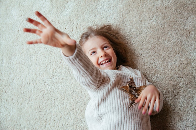 Bambina bionda sul pavimento con il solletico