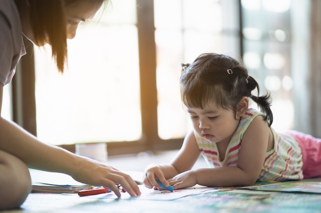 Bambina carina che dipinge con sua madre a casa