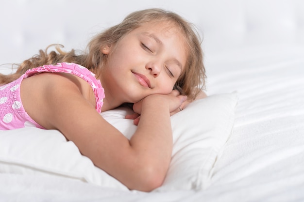 Bambina carina che dorme in un letto