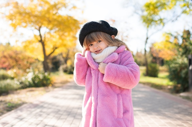 Bambina carina che indossa un soffice cappotto rosa e un cappello