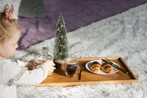 Bambina carina che serve la colazione per mamma o papà