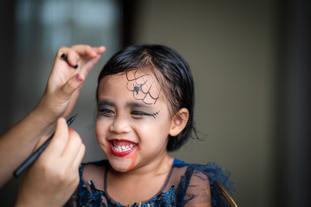 Bambina carina con il trucco di halloween sul viso