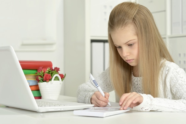 Bambina carina e laptop a casa