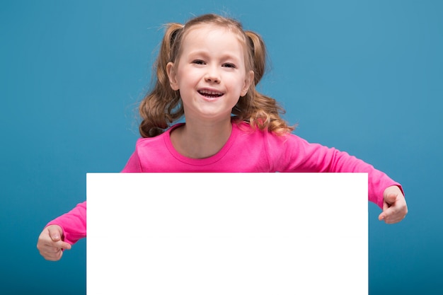 bambina carina in camicia rosa con scimmia e pantaloni blu tenere cartello vuoto vuoto