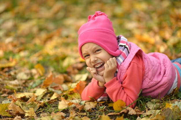 Bambina carina in un parco autunnale