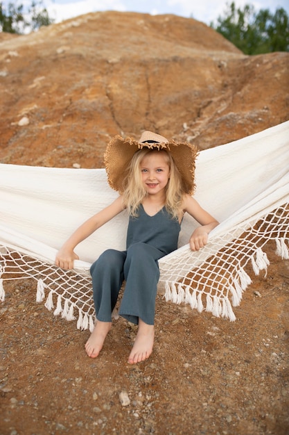 Bambina carina in vestiti alla moda in uno scenario naturale