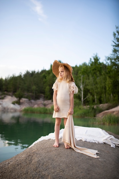 Bambina carina in vestiti alla moda in uno scenario naturale