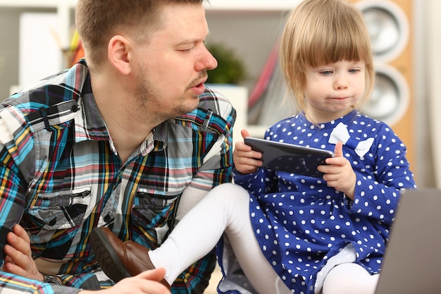 Bambina carina sul tappeto del pavimento con papà