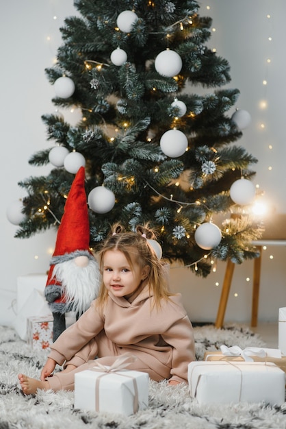 Bambina carina vicino all'albero di Natale