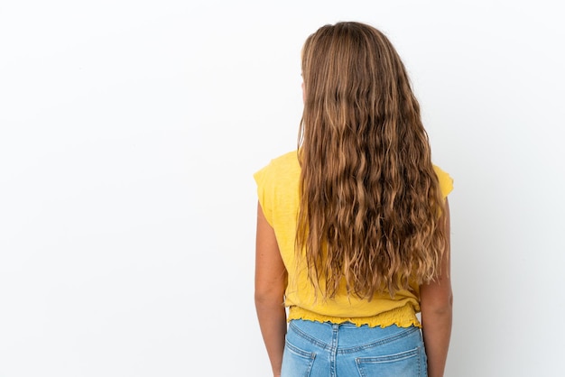 Bambina caucasica isolata su sfondo bianco in posizione posteriore e guardando di lato