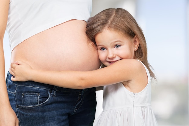 Bambina che abbraccia la madre incinta