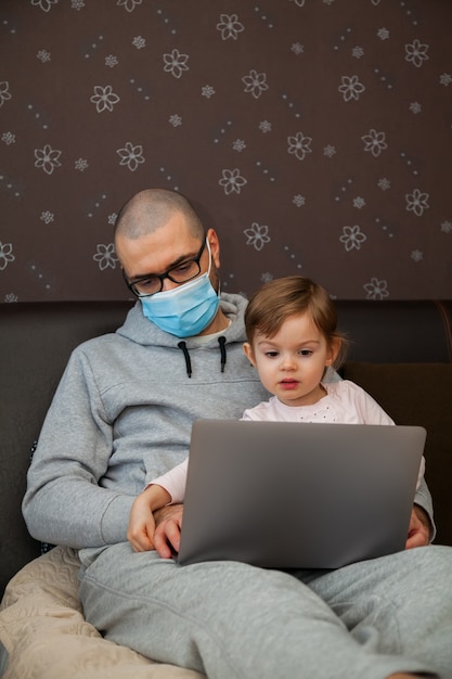 Bambina che aiuta suo padre a lavorare su un computer portatile