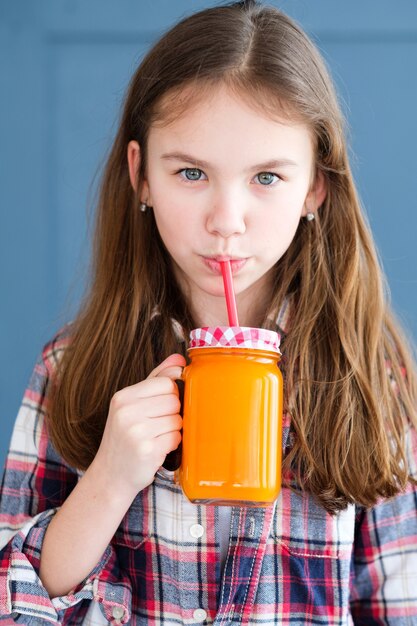 bambina che beve bevanda fresca con una cannuccia.