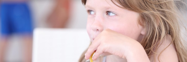 Bambina che beve cocktail analcolici dalla paglia al bar sulla spiaggia?