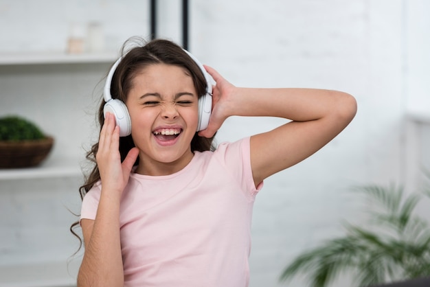 Bambina che canta mentre ascolta la musica tramite le cuffie