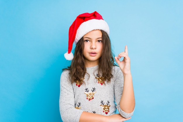 Bambina che celebra il giorno di Natale che ha una grande idea, concetto di creatività.